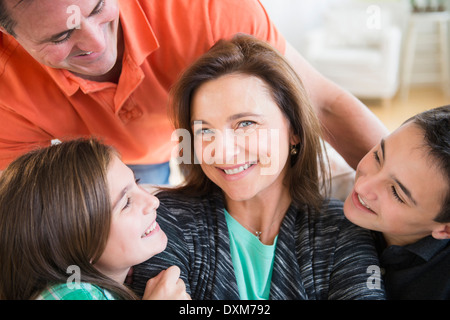 Caucasian man and children smiling at woman Stock Photo