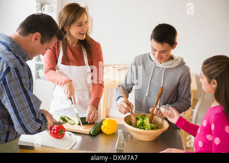 Caucasian family preparing salad in kitchen