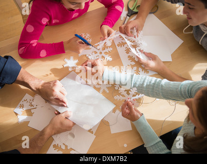 Caucasian family cutting out paper snowflakes Stock Photo