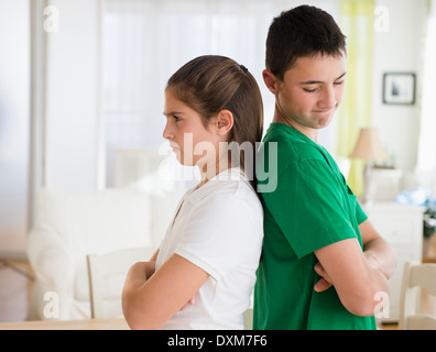 Angry Caucasian brother and sister standing back to back Stock Photo