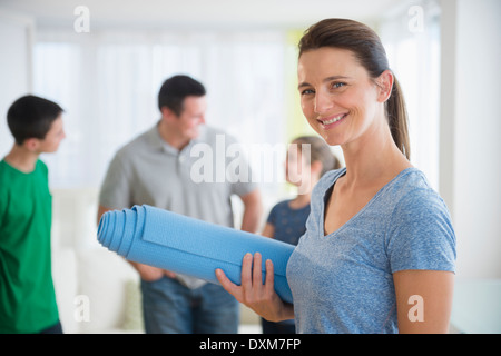 Portrait of smiling woman holding yoga mat Stock Photo