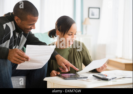 Couple paying bills in living room Stock Photo