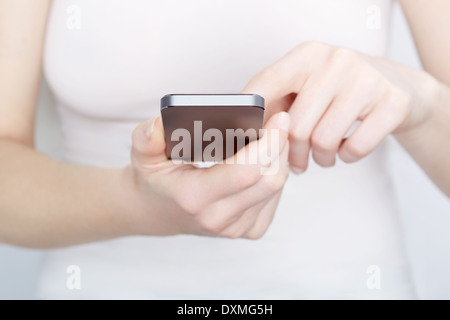 Close up of woman in white using a modern smartphone Stock Photo