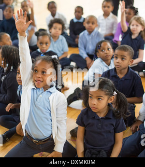 Kindergarten and first grade students at Chrysler Elementary School ask questions after an author has read her children's book. Stock Photo
