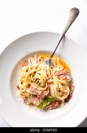Pasta Carbonara on white plate with parmesan and yolk Stock Photo
