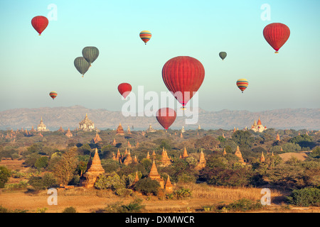 Multicolored hot air balloons over Buddhist temples at sunrise. Bagan, Myanmar. Stock Photo