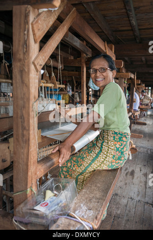 Woman weaving silk cloth on a hand loom, Inle Lake, Myanmar Stock Photo