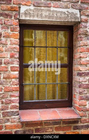 Window of a medieval building with very old brick wall Stock Photo