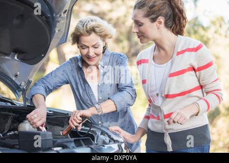 Mother and daughter jump starting car Stock Photo