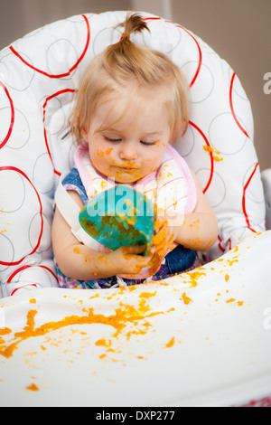 Little baby making a mess with her food Stock Photo