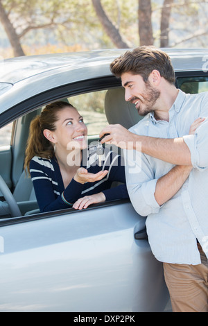 Man giving woman in car keys Stock Photo