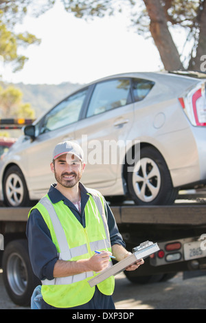 Portrait of confident roadside mechanic with paperwork Stock Photo