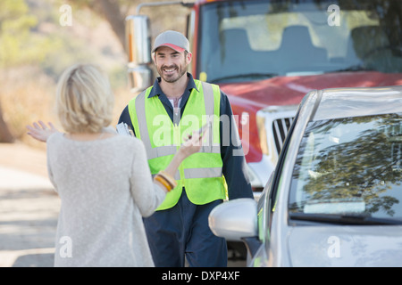 Woman greeting roadside mechanic Stock Photo