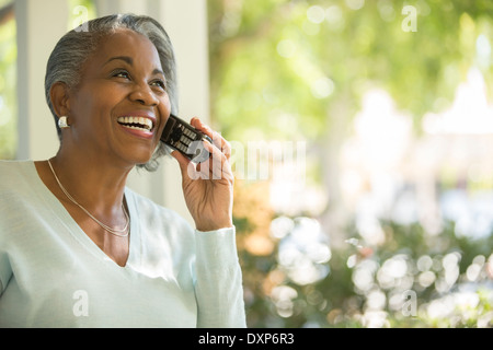 Happy senior woman talking on telephone outdoors Stock Photo