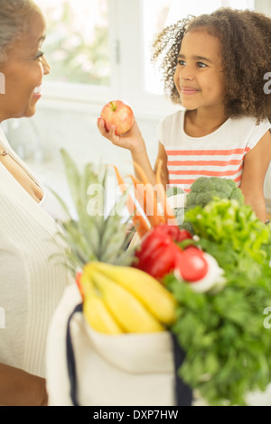 Grandmother and granddaughter unpacking groceries Stock Photo