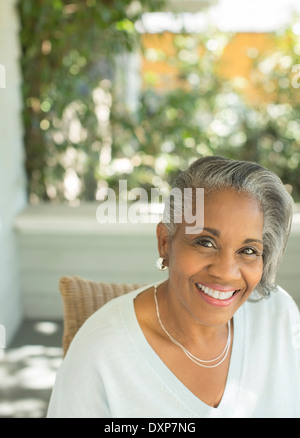 Portrait of smiling senior woman on porch Stock Photo