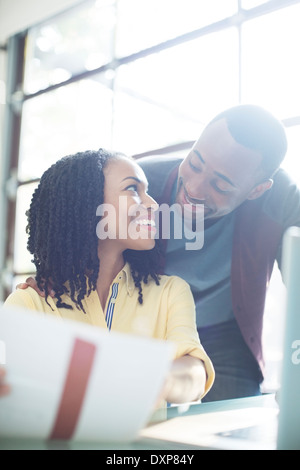 Happy couple with paperwork at laptop Stock Photo