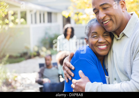 Close up portrait of happy senior couple hugging on patio Stock Photo