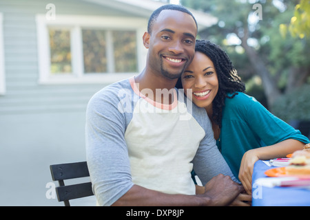 Portrait of happy couple holding hands at patio table Stock Photo