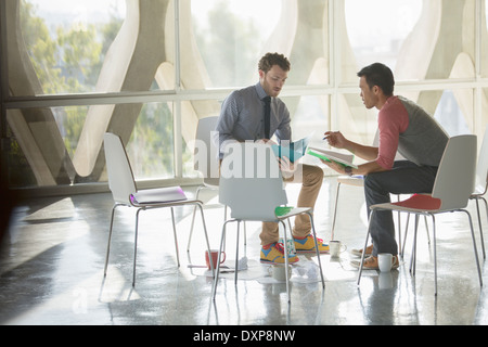 Creative businessmen brainstorming in circle of chairs Stock Photo