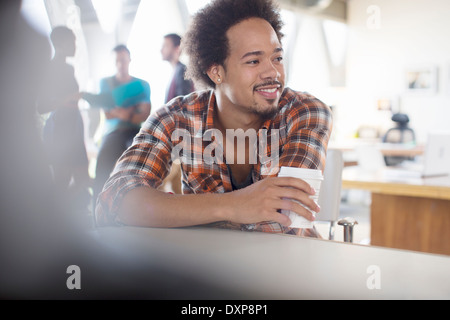 Creative businessman drinking coffee in office Stock Photo