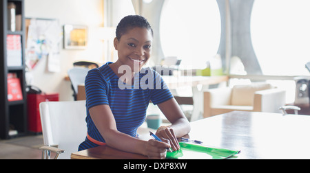 Portrait of confident businesswoman working at desk in sunny office Stock Photo