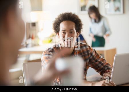 Happy creative businessman using laptop in meeting Stock Photo