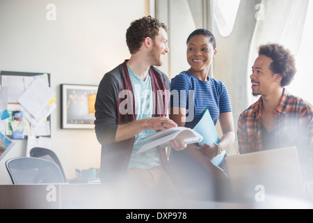 Casual business people discussing paperwork in meeting Stock Photo