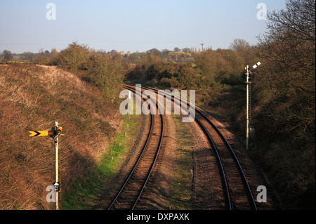 A dual track railway line with signals on the approach to Reedham Swing Bridge, Norfolk, England, United Kingdom. Stock Photo