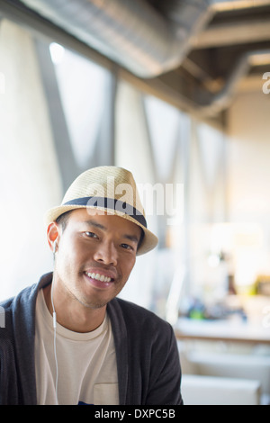 Portrait of smiling casual businessman in fedora Stock Photo