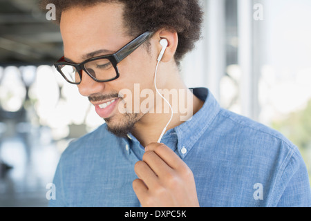 Close up of man in eyeglasses listening to music on headphones Stock Photo