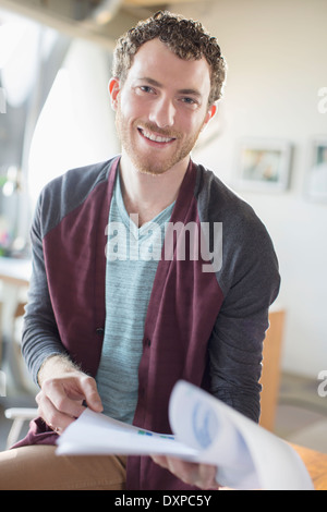 Portrait of smiling casual businessman with paperwork in office Stock Photo