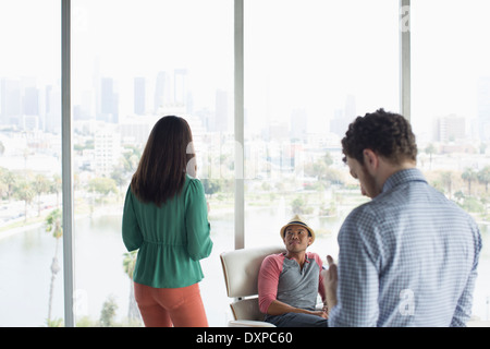 Casual business people in office overlooking city Stock Photo
