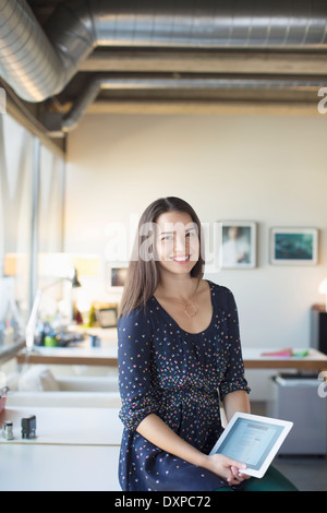 Portrait of smiling businesswoman with digital tablet in office Stock Photo