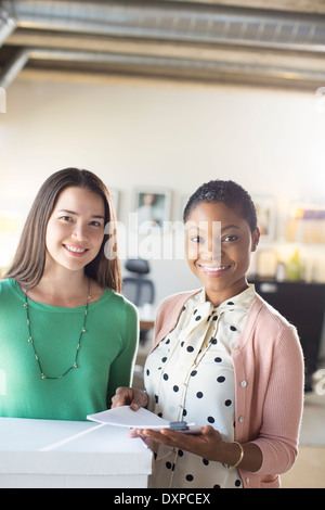 Portrait of smiling businesswomen with paperwork in office Stock Photo
