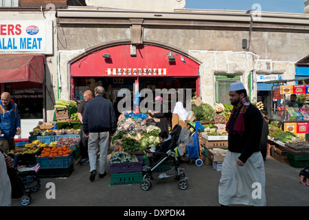 People buying fruit and veg at Bangla Bazaar in Whitechapel Road Market  East London E1 UK KATHY DEWITT Stock Photo