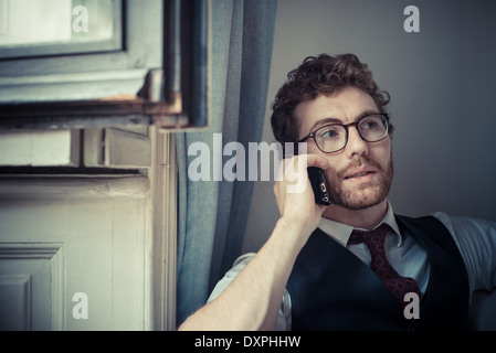 elegant attractive fashion hipster man on the phone at home Stock Photo