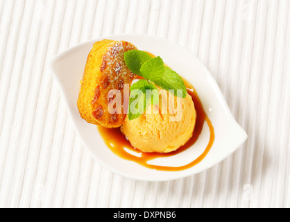 Small Dutch oval-shaped cake (Roomboter kano) with ice cream and caramel syrup Stock Photo