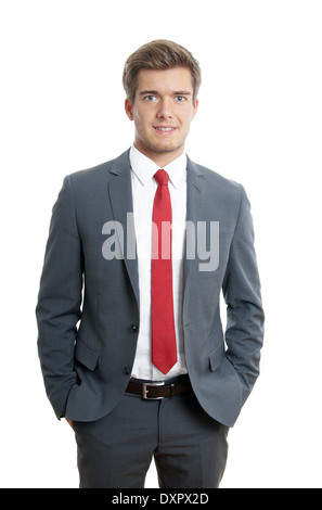 young businessman wearing suit and tie standing with hands in his pockets Stock Photo