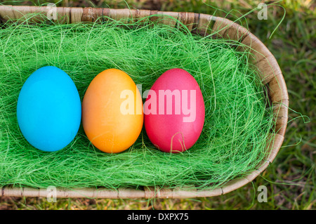 Tree Easter Eggs in a basket on a grass Stock Photo