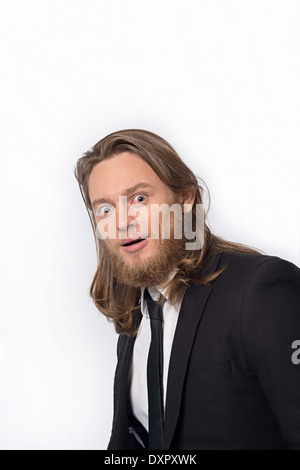 A bearded long hair man in suit looking stunned and surprised. A head and shoulder funny portrait Stock Photo
