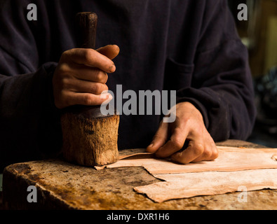 Hands working on leather on a shop in Rabat Medina, Morocco Stock Photo