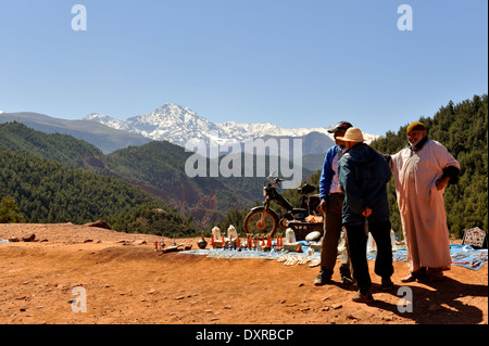 Roadside viewpoint of Atlas mountains on way to Oukaimeden with men set to sell souvenirs to tourists Stock Photo
