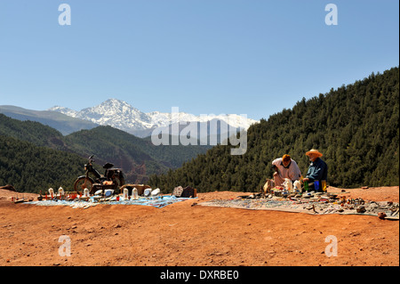 Roadside viewpoint of Atlas mountains on way to Oukaimeden with men set to sell souvenirs to tourists Stock Photo