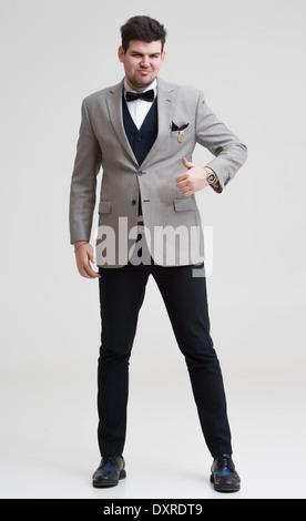 European businessman in triple suit. Handsome man. Euro logo icon pinned to the suit. Make hands binokular. Stock Photo