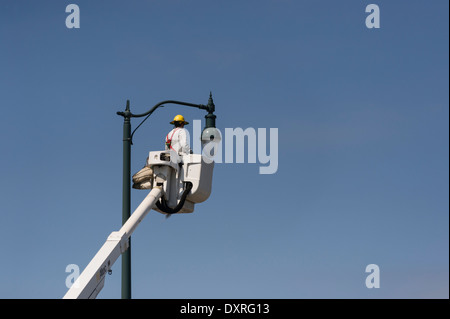 Man in Aerial Bucket Truck changing light bulb in Leesburg, Florida USA Stock Photo