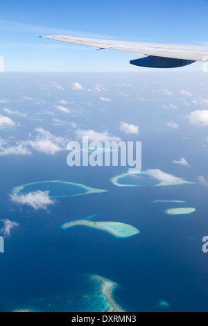View from the window of an airplane flying above the Maldive Islands in the Indian Ocean Stock Photo