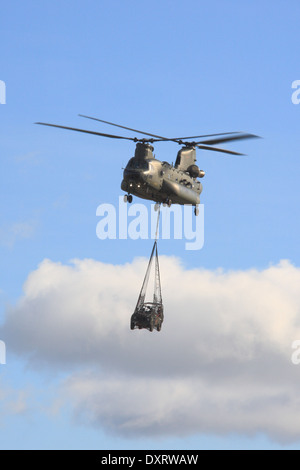 RAF Chinook helicopter carrying an Army Land Rover as an under slung load on Salisbury Plain Training Area. Stock Photo