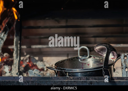 close up of a metal casserole and soup ladle in oven, outdoor horizontal shot Stock Photo