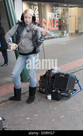 Young woman street musician playing classical music on an electronic violin in Middlesbrough town centre Stock Photo